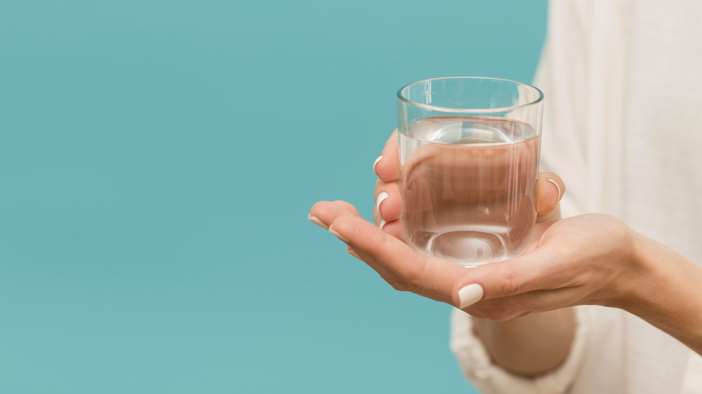 woman-holding-glass-filled-with-water-copy-space